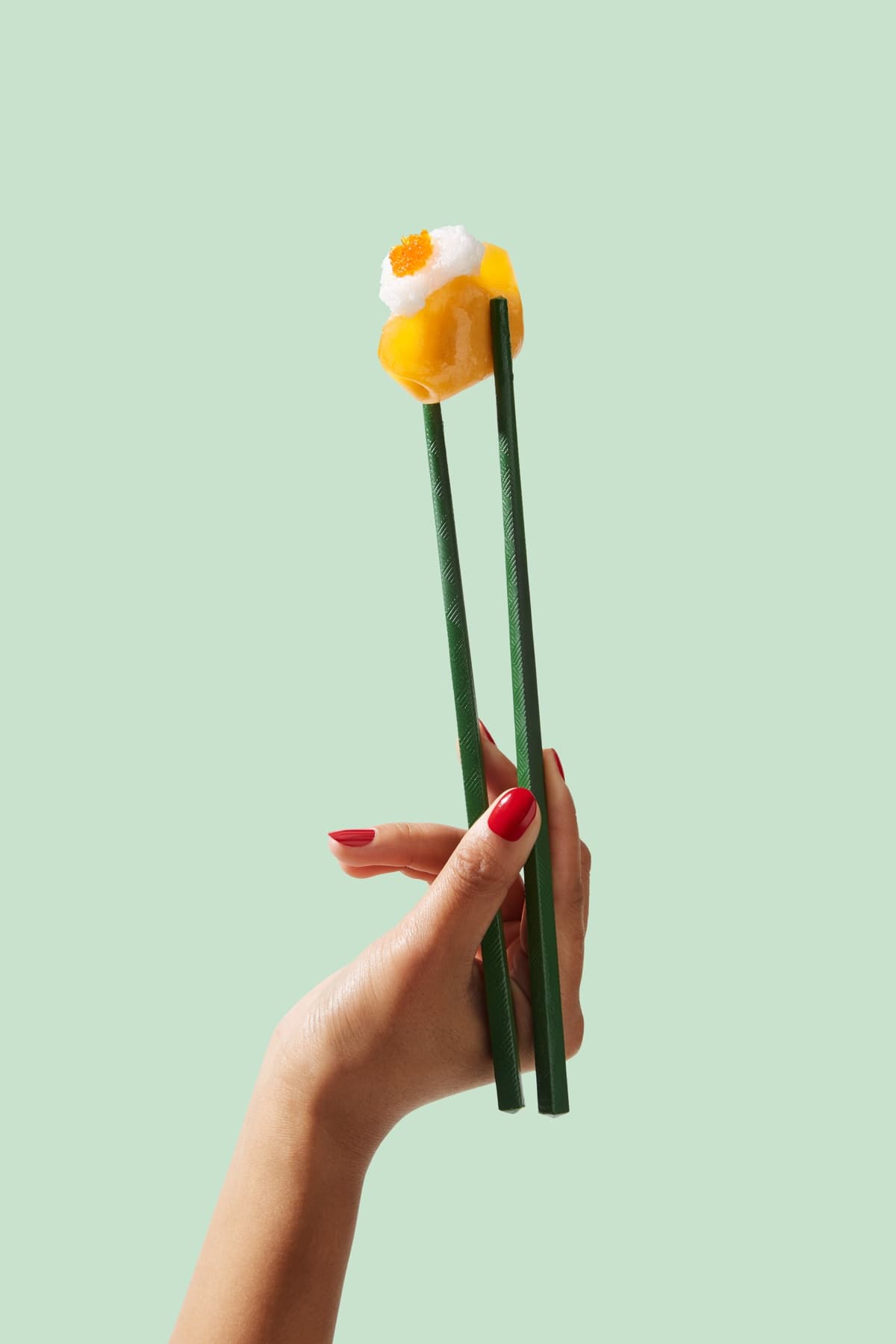 A MURO dumpling held in green chopsticks